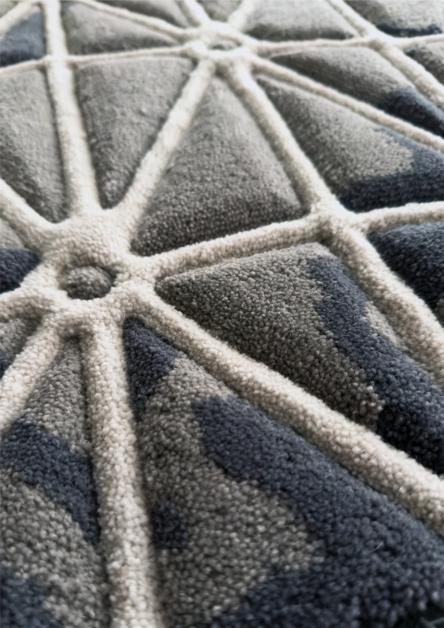 Detalle de surcos y relieves en una alfombra de dibujo geométrico.
